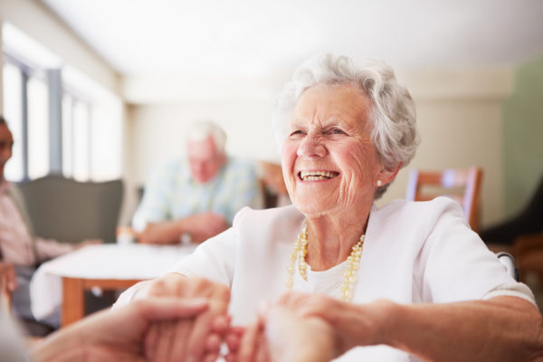 An elderly woman being helped up by a nurse